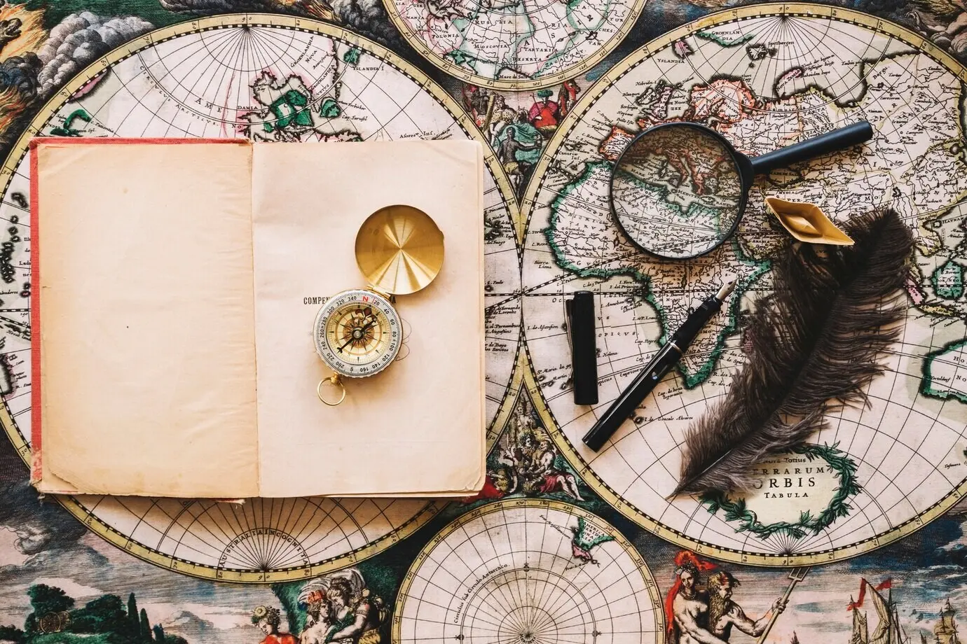 Kompass auf einem Notizbuch neben Schreibutensilien